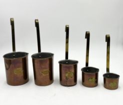 A nesting set of vintage copper measuring jugs