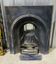 A Victorian cast iron fireplace with arched design