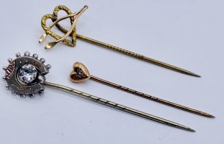 A 9ct gold tie pin set with a seed pearl along with a yellow metal tie pin and one other