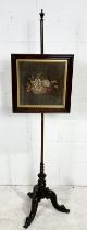 An antique rosewood pole screen with tapestry panel on tripod base