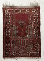 A red ground Eastern prayer rug with geometric design 104cm x 76cm
