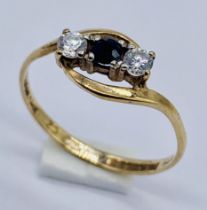 A 9ct gold three stone ring set with a sapphire