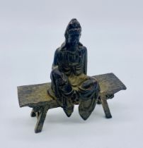 A small patinated copper Buddha seated on an altar bench, height 8cm