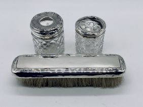 Two hallmarked silver topped dressing table pots (1 A/F) along with a silver brush