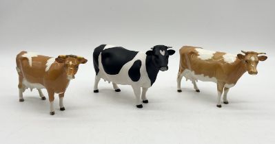 Three Beswick cows comprising of two Guernsey cows and a matt Friesian example