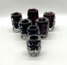 A collection of seven Liskeard Glass purple art glass vases.