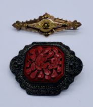 A vintage cinnabar brooch in SCM setting along with a Victorian gold coloured brooch (tests as