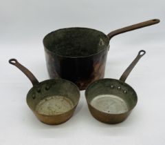 An antique copper saucepan, along with two smaller ones