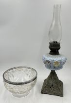 A cut glass bowl with hallmarked silver rim along with an antique oil lamp