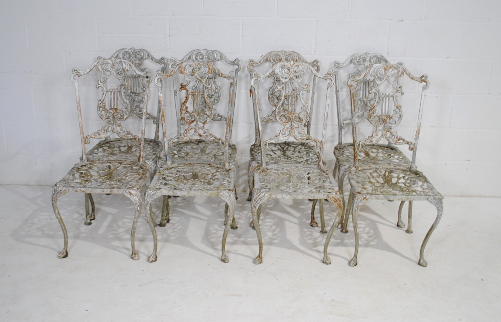 A weathered cast aluminium circular garden table with a set of eight chairs, with lyre backs - one - Image 8 of 12