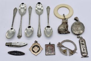 A collection of silver items including coffee spoons, rattle in the form of a cat, silver bladed