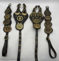 A collection of antique and later horse brasses on leathers