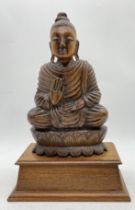 A carved wooden Buddha seated on double lotus throne