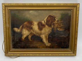A small oil painting circa 1900 of a spaniel with a game bird, overall size 26cm x 36cm