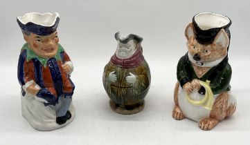 A Majolica "jolly friar" jug stamped England to base along with a Toby jug modelled as Mr Punch