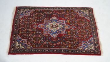 A small red ground Eastern rug - 125cm x 78cm