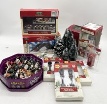 A collection of Lemax and similar accessories for the Christmas village including figures, trees