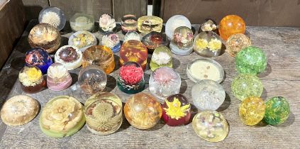 A collection of vintage lucite/resin paperweights, most with floral specimens set within