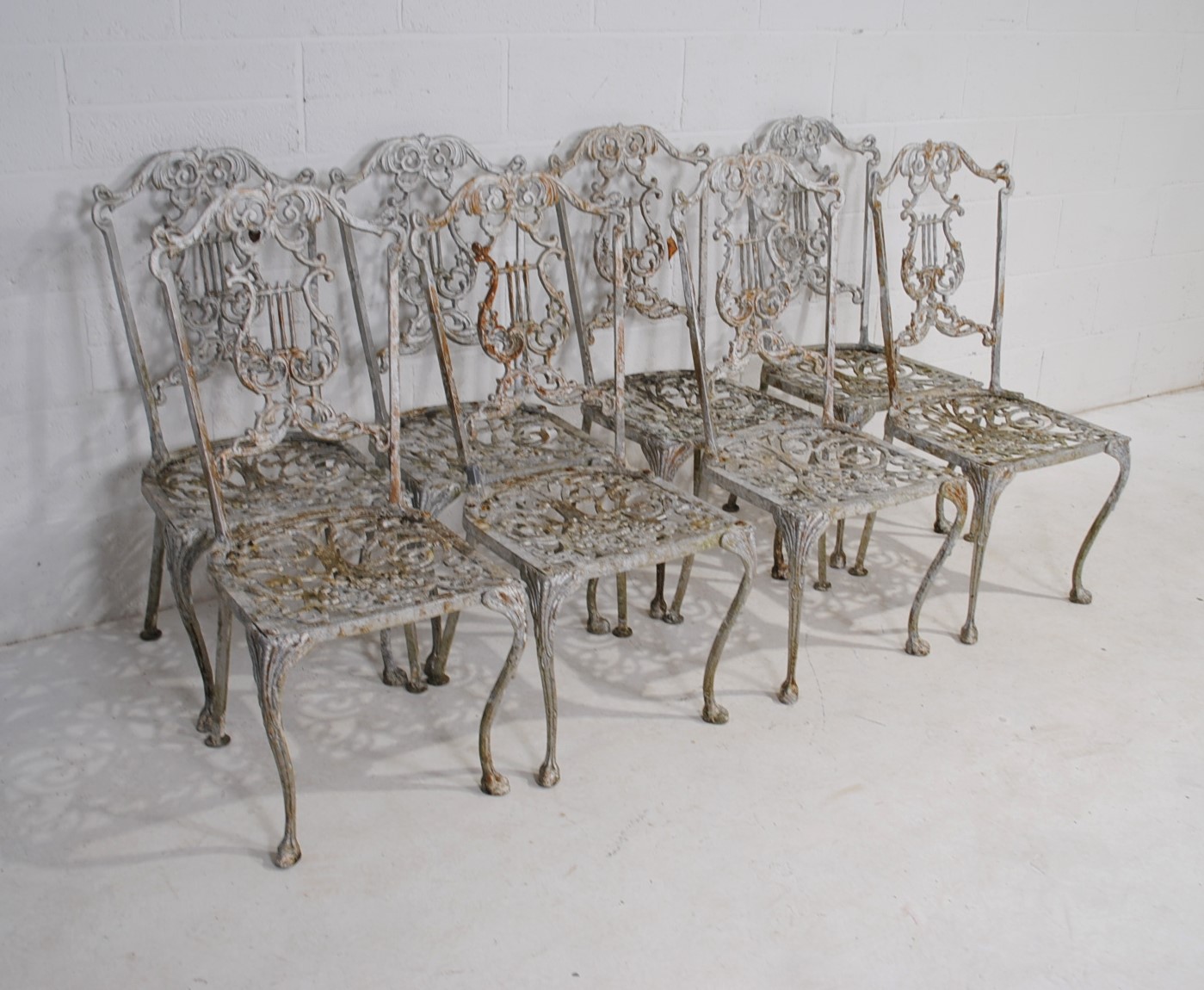 A weathered cast aluminium circular garden table with a set of eight chairs, with lyre backs - one - Image 10 of 12