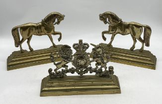 Three antique brass doorstops, two in the form of horses and the other with royal coat of arms