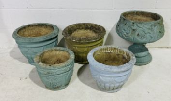 A collection of five concrete garden pots, four painted blue.