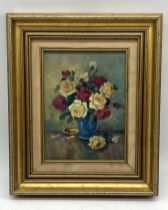 A gilt framed oil on canvas of red and yellow roses in a vase signed MS to lower left. Overall