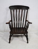 An antique Windsor nursing chair, with elm seat with impressed initials 'JS' to the back