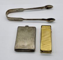 A hallmarked silver matchbook case, silver sugar tongs and a gold plated Dunhill lighter