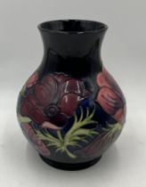 A Moorcroft vase in the Anemone pattern on dark blue background - height 24cm