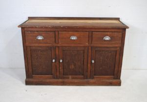 A stained pine dresser base, with three drawers and cupboards under - length 150cm, depth 83cm,
