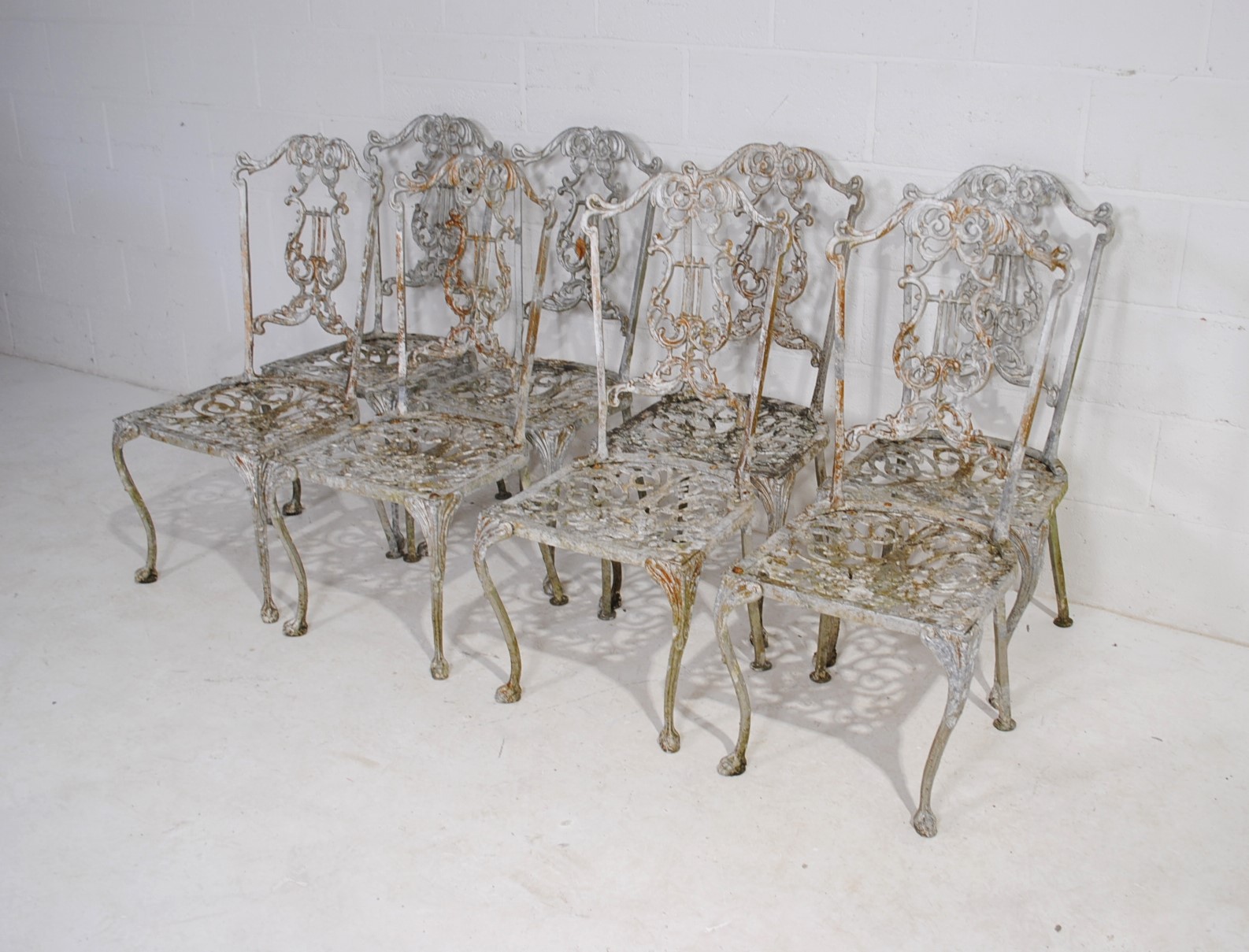 A weathered cast aluminium circular garden table with a set of eight chairs, with lyre backs - one - Image 9 of 12