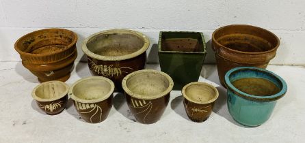 A small collection of glazed garden pots, along with two terracotta pots