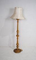 A gilt standard lamp with silk shade
