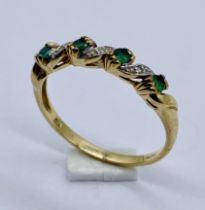 A diamond and emerald dress ring set in 9ct gold, size R