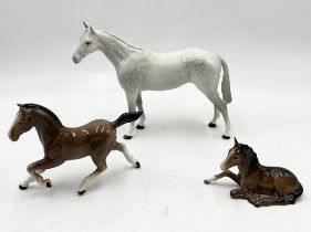 A Beswick dapple grey racehorse along with a bay foal and one other