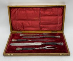 A Victorian oak cased five piece carving set with silver mounts depicting rams heads, by Joseph