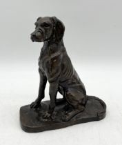 A bronze figure of a hound dog in seated position - height 22cm