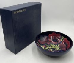 A boxed Moorcroft Anemone pattern fruit bowl with signature for John Moorcroft - diameter 26cm