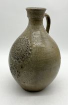 A Bellarmine style salt glazed jug with impressed detail to front and signed SP - height 33cm