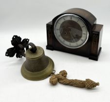 A brass bell on cast iron bracket along with an oak cased mantle clock