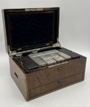 A brass bound burr walnut silver fitted dressing box with an arrangement of silver lidded bottles (