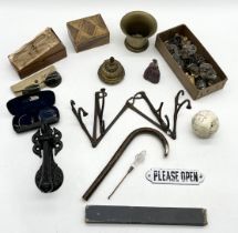 An assortment of items including antique folding set of coat hooks, ink well, lead figure, glasses