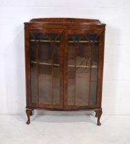 A bow-fronted wooden display cabinet, raised on cabriole legs - length 91cm, depth 31cm, height