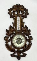 A carved wooden barometer, made in Germany