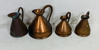 A collection of four various sized copper jugs - largest is three gallons