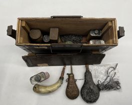 A vintage ammo box containing powder flasks & shooting paraphernalia.