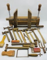 A small collection of tools including several hammers, saw, wooden scrapers etc