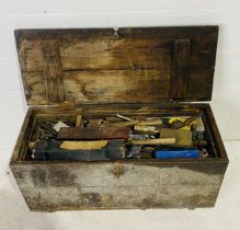 A wooden carpenter's truck, full with various tools including hammers, chisels, drill bits, axes etc