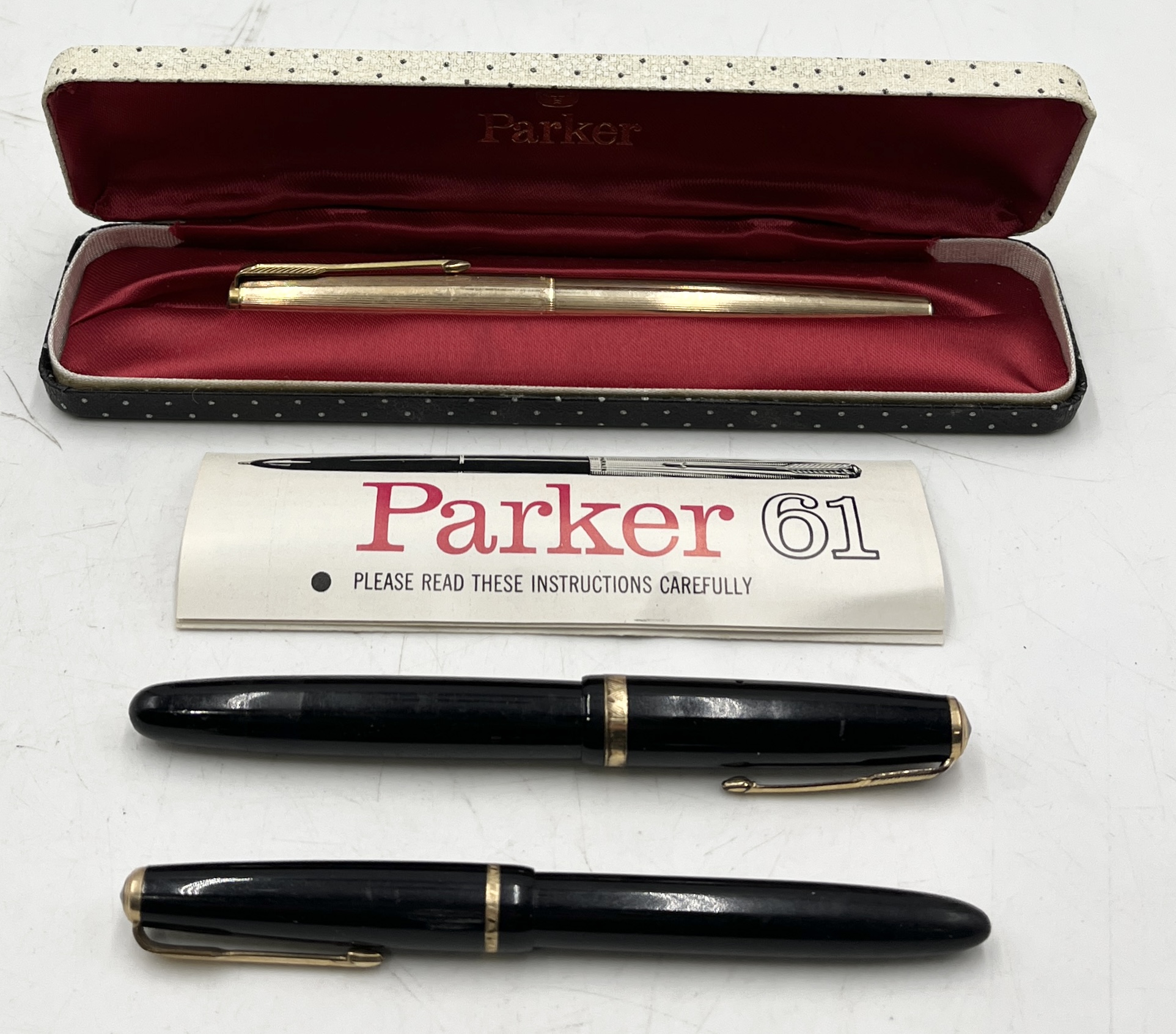 A cased Parker 61 gold plated fountain pen along with a Parker Duofold and a Parker Slimfold