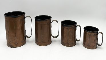 A collection of four copper tankards in descending size